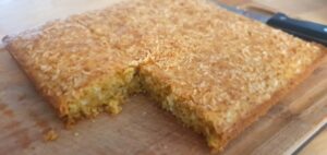 Photo d'un gateau carré orangé sur une planche en bois